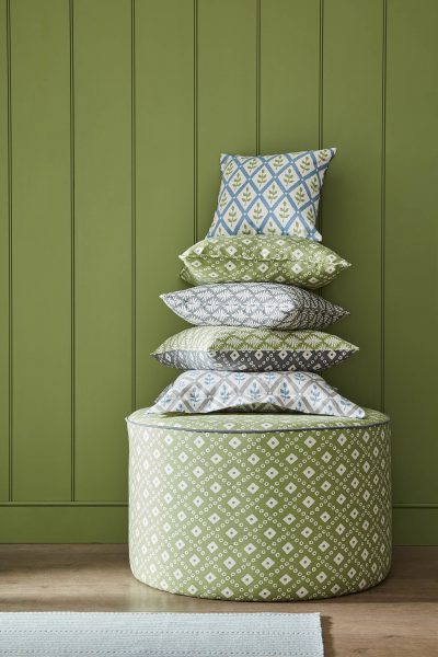 fabric covered pouffe in green with fabric covered cushions