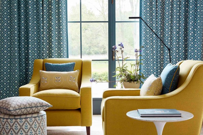 Yellow armchairs against blue curtains